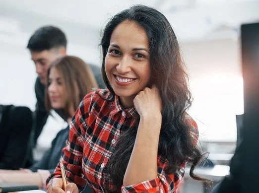 Smiling learner taking notes in a class